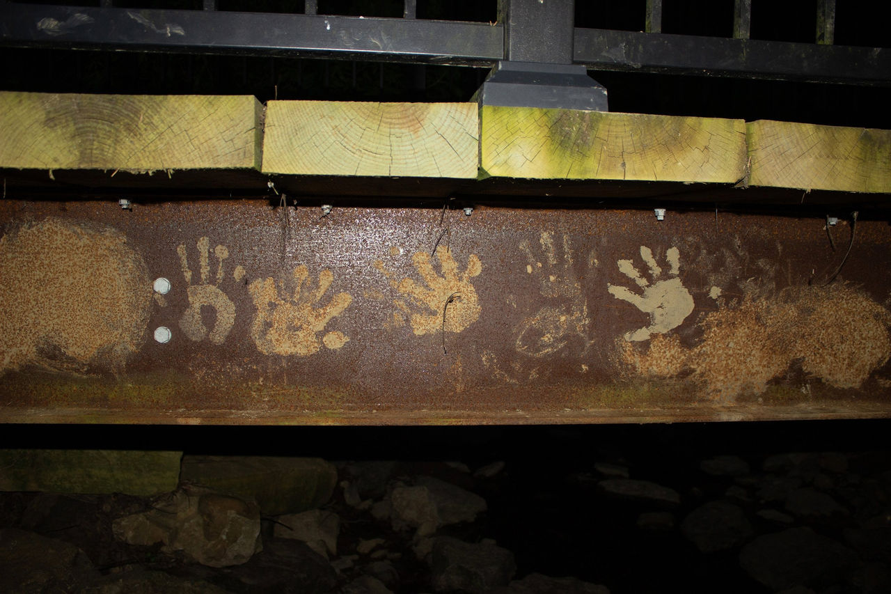 photograph of a bridge trussle with handprint graffiti