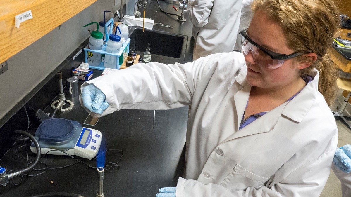 student using microscope