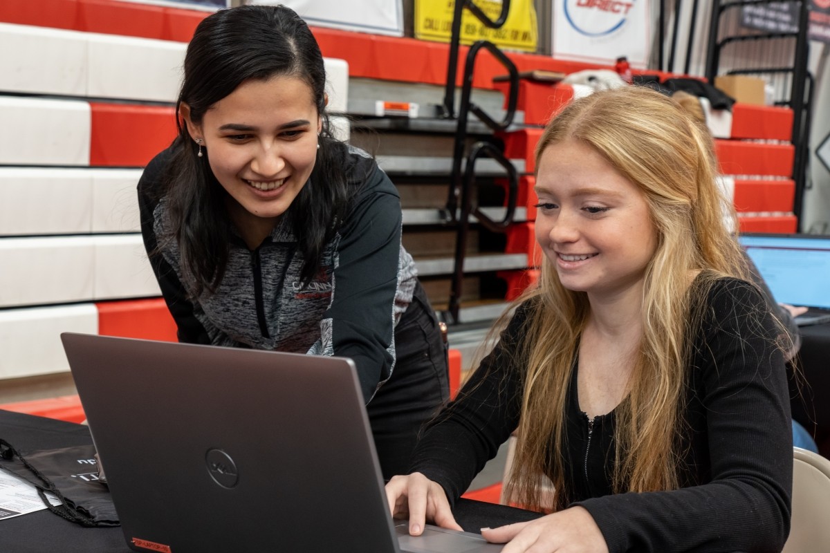 student reading viewbook in front of welcome sign