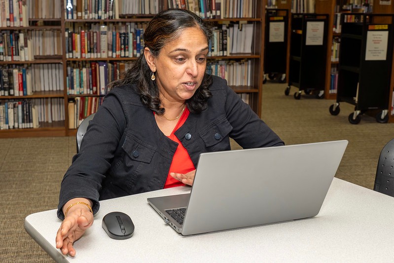 professor leaning over a student working at a computer